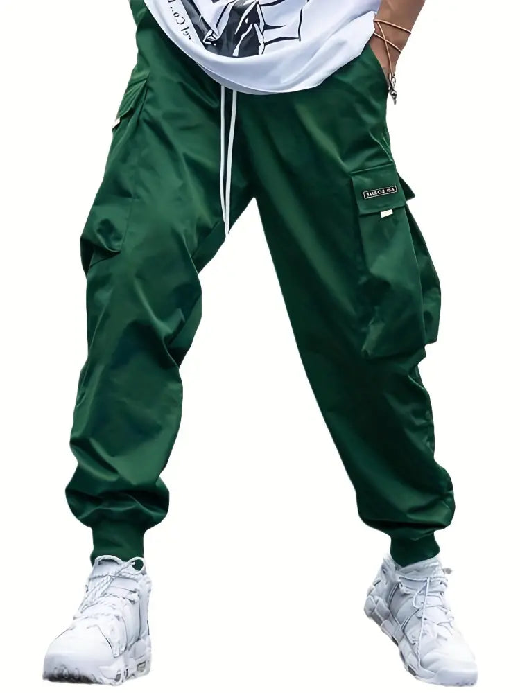Men’s dark green cargo joggers with multiple pockets and a drawstring waistband for streetwear style