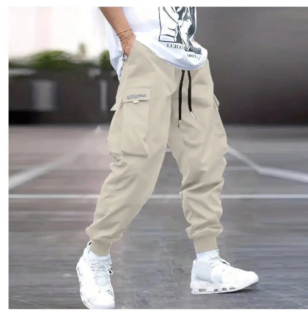 Men’s beige multi-pocket streetwear cargo joggers with side pockets and black drawstrings for casual wear