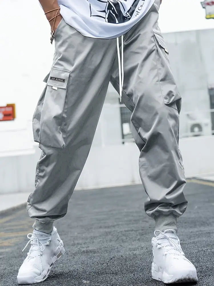 Men’s gray cargo joggers with multiple pockets and a drawstring waistband for streetwear style