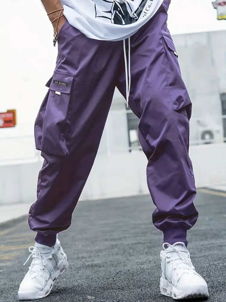 Purple men’s multi-pocket streetwear cargo joggers with drawstring waistband designed for casual urban wear