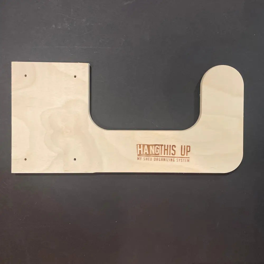 Light-colored wooden u-shaped utility storage hooks engraved with hang this up and my shed organizing system