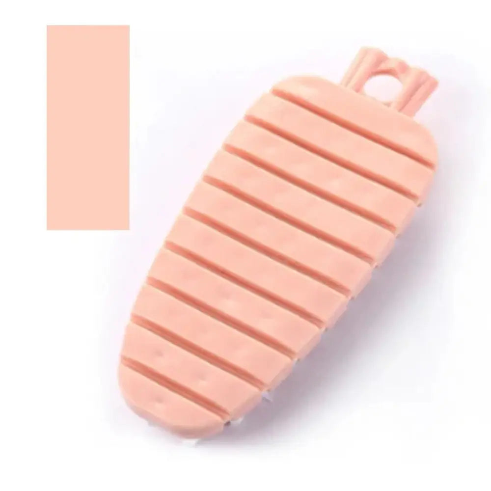 A peach-colored flexible silicone carrot-shaped vegetable and fruit cleaning brush with horizontal ridges and looped top