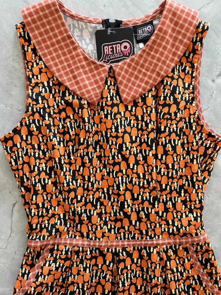 A sleeveless black cotton 60s retro a-line dress with orange mushroom print coral plaid collar and waistband trim