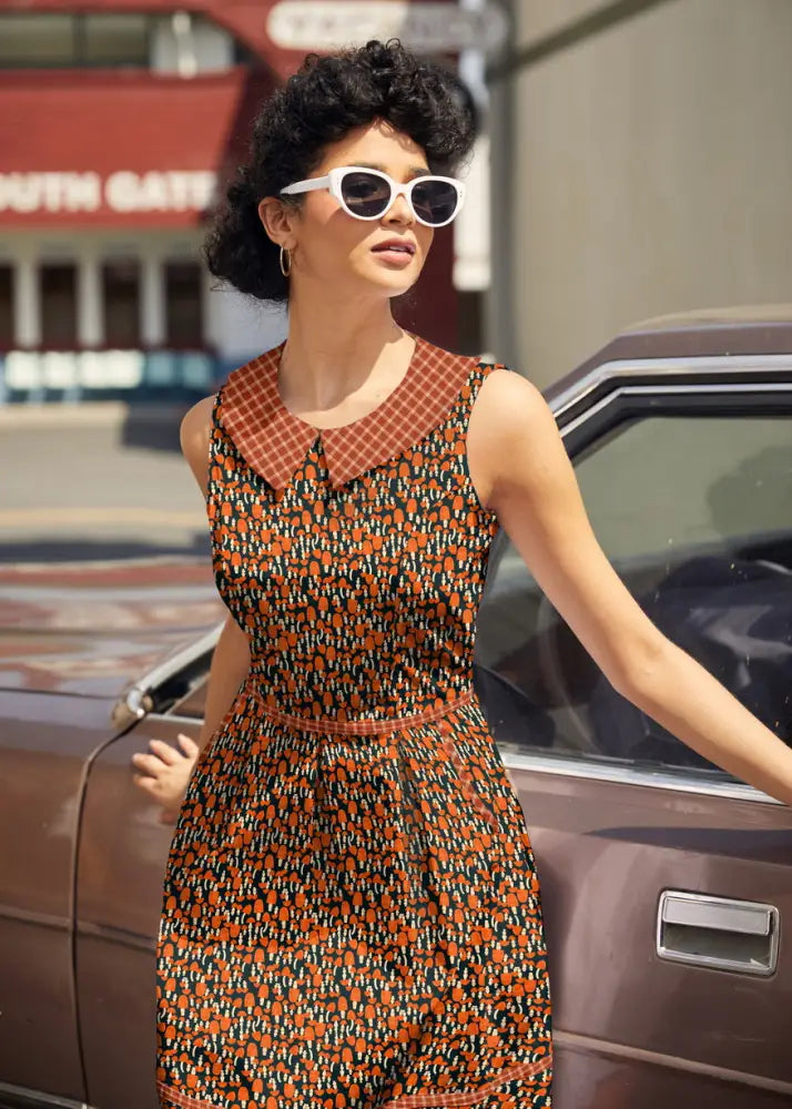 Sleeveless retro 60s mushroom print cotton A-line dress with bold orange and black pattern and red brown checkered collar