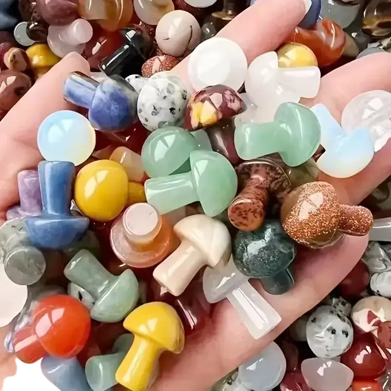 A hand holds colorful polished natural crystal mushroom figurines in various hues for mini garden decor