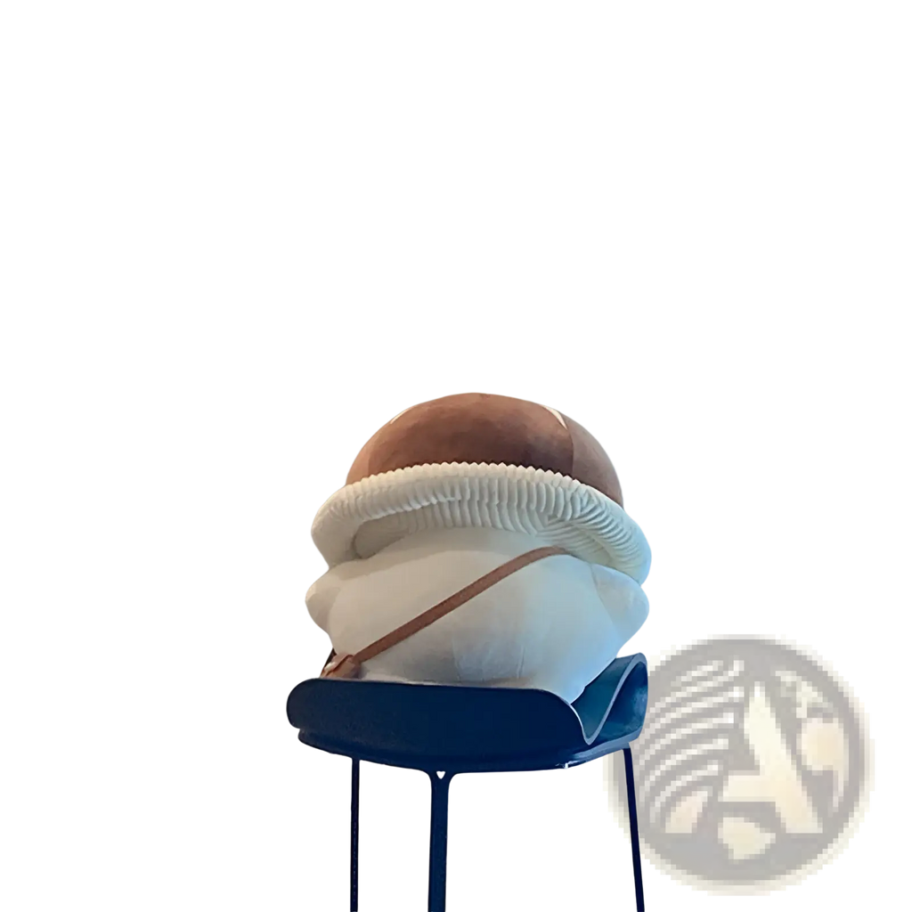 A plush brown and white corduroy bread shaped pillow with textured ribbed edges on a blue bar stool