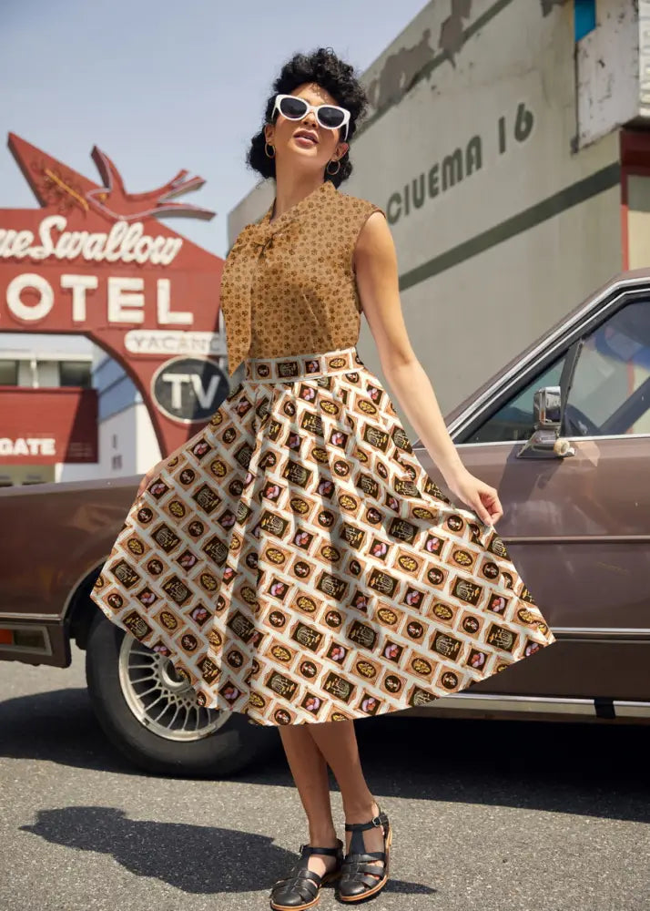 A vintage-style sleeveless tan and brown polka dot cotton top with bow neckline paired with vintage mushroom portrait print skirt