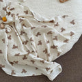 Muslin bear print baby bath towel and swaddle blanket in soft off-white cotton muslin with quilted texture and teddy bear prints