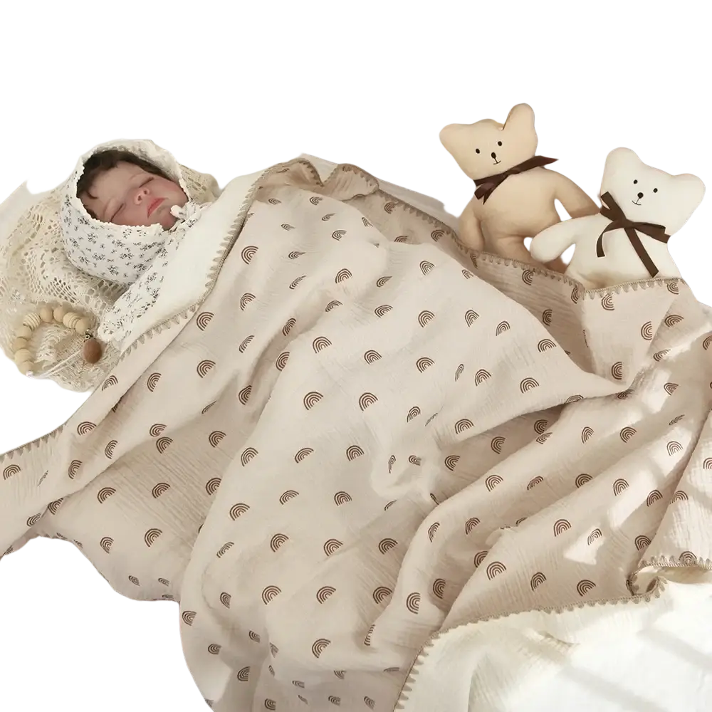 Beige muslin cotton baby swaddle blanket with subtle brown rainbow pattern and stitched edges gently wrapped around baby