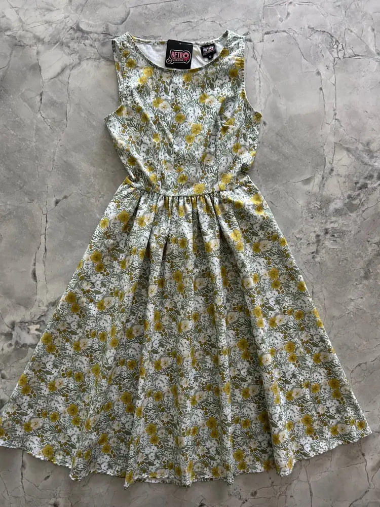 A sleeveless vintage mustard floral cotton midi dress with pockets in yellow and green on a light background