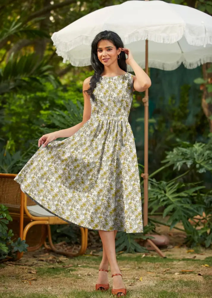 A woman wearing a vintage mustard floral cotton midi dress with pockets in light green and white floral pattern