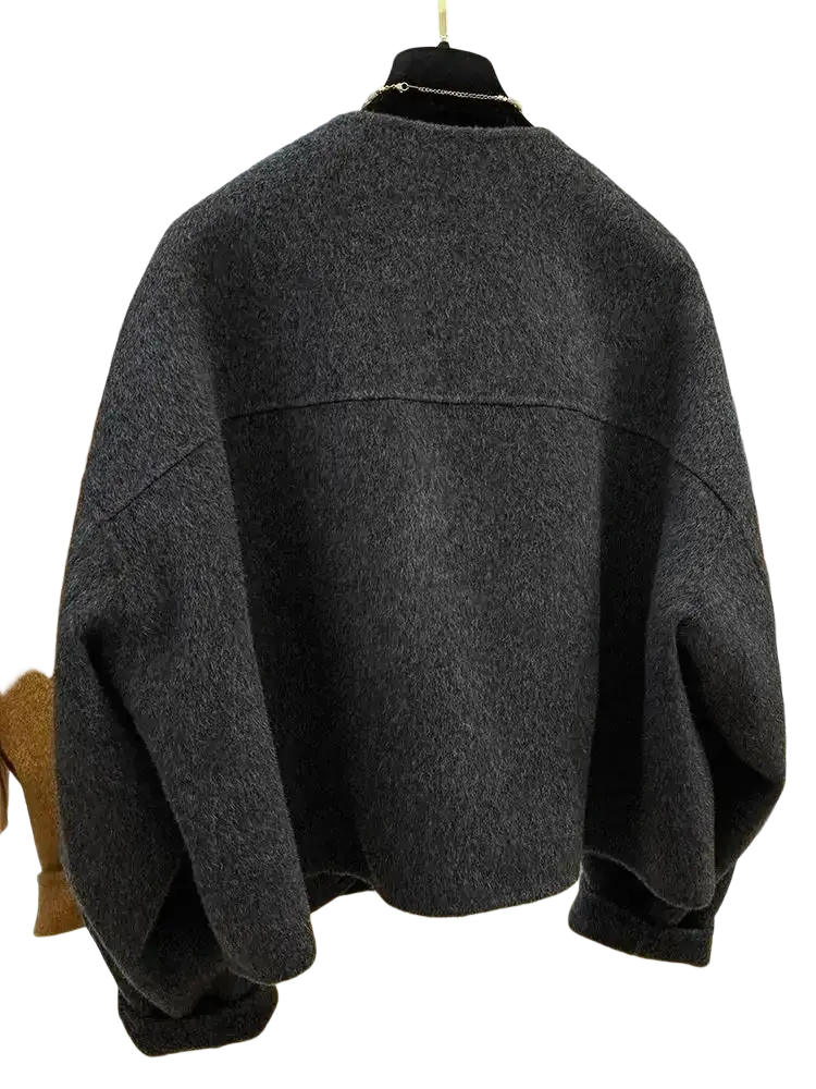 Dark gray oversized knit sweater with relaxed fit and ribbed cuffs paired with mustard yellow wool blend short coat women