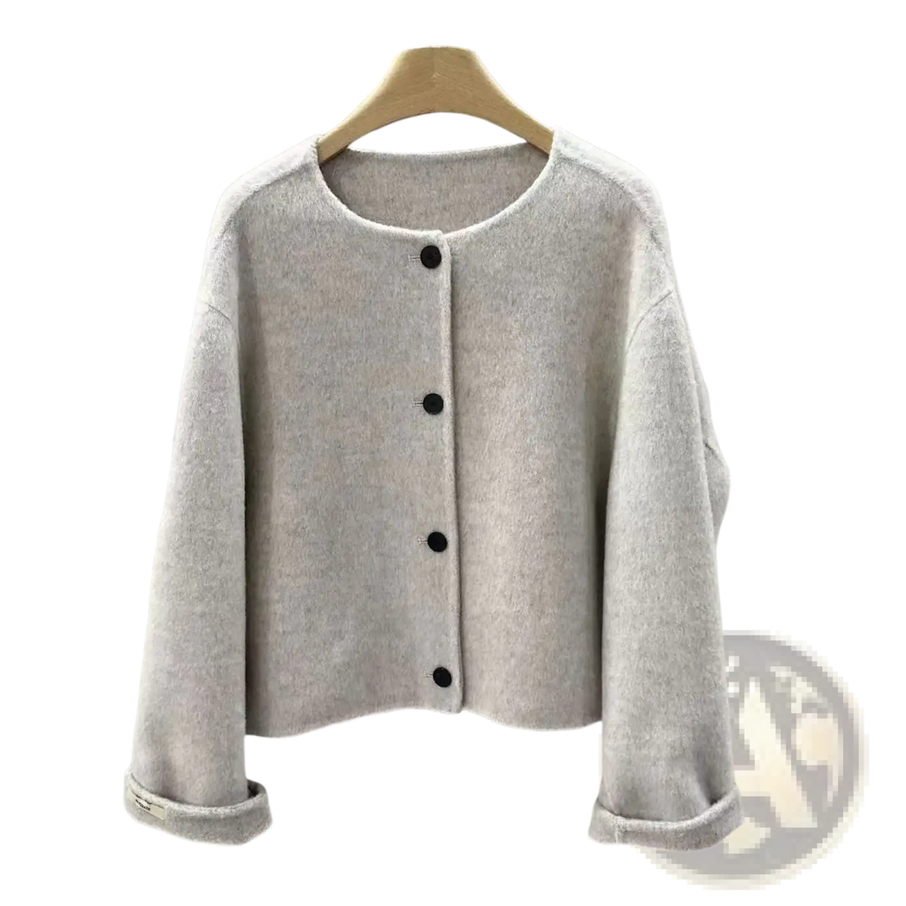 A soft light gray knit cardigan with black buttons and rolled cuffs for women complementing a mustard yellow wool blend short coat