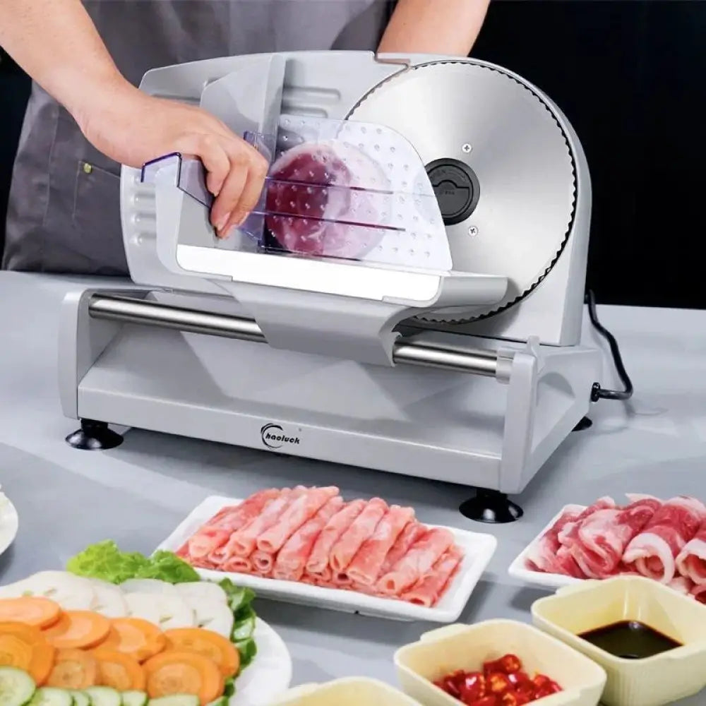 Adjustable electric meat and deli slicer with silver and black metal body, precision rotating blade, clear plastic guard, and guide