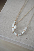 Mykonos white ceramic and gold beaded chain necklace with curved design segmented beads and central pearl accent