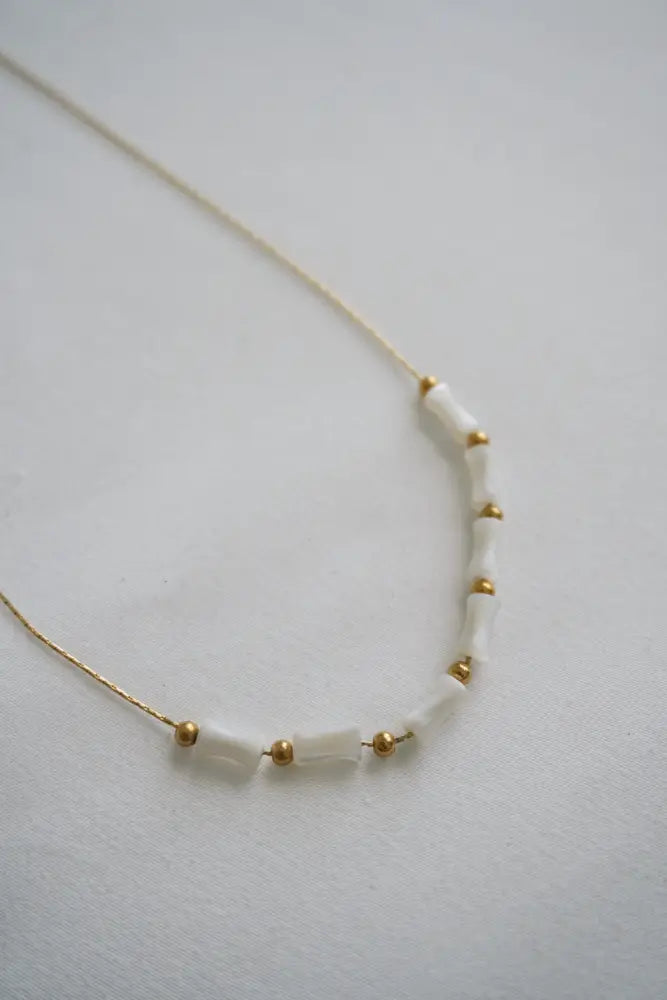 Mykonos white ceramic and gold beaded chain necklace with translucent white beads and gold-toned spheres on a fine gold chain