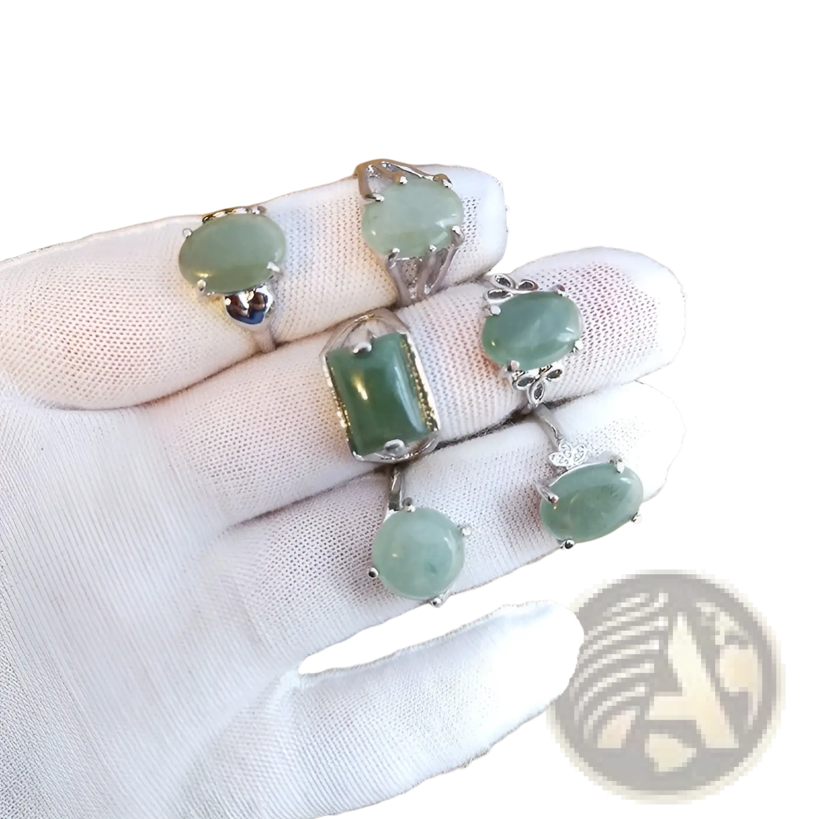 A hand in a white glove displays five natural gemstone silver tone statement rings with green jadeite stones