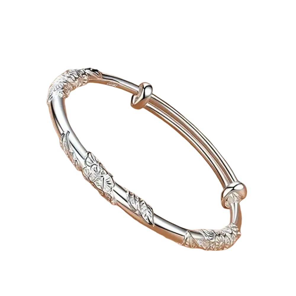 Delicate silver floral-patterned bangle with intricate designs and secure clasp featuring natural jade raw stone