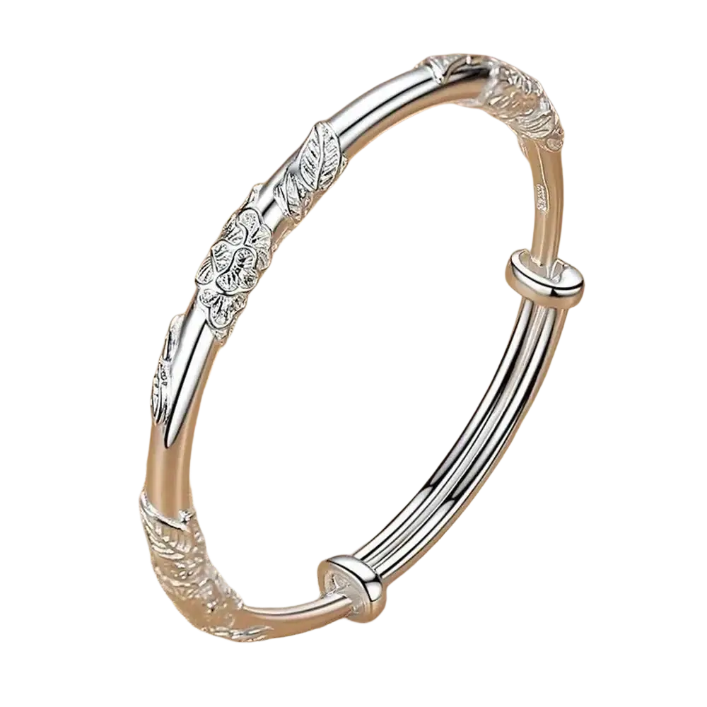 Silver bangle bracelet with intricate floral and leaf engravings and a polished finish featuring natural jade raw stone details