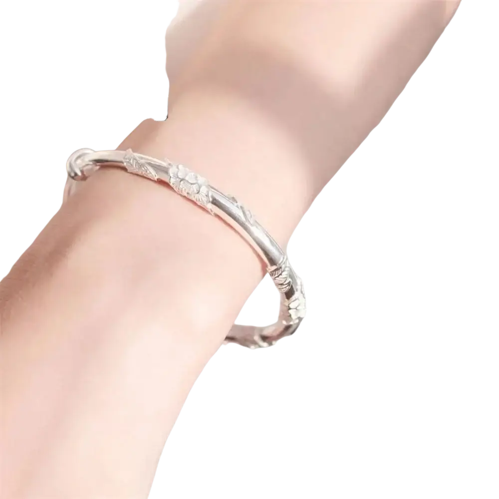 Silver floral-patterned bangle bracelet with intricate engravings featuring natural jade raw stone sliding design