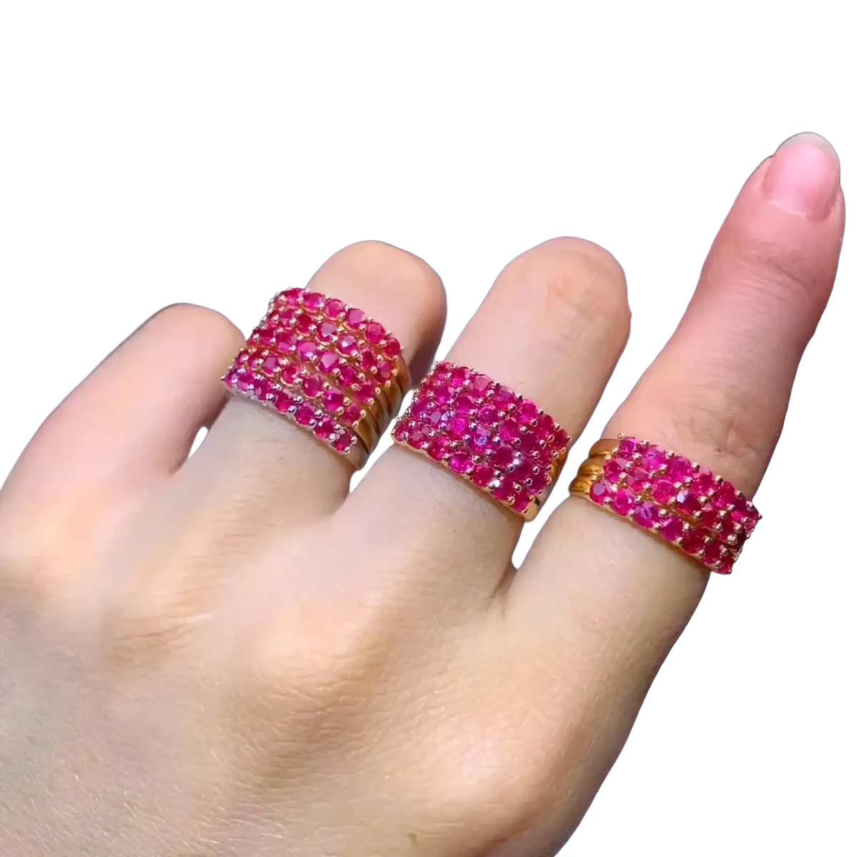Three stacked natural ruby silver ring bands with gold settings displayed on a hand
