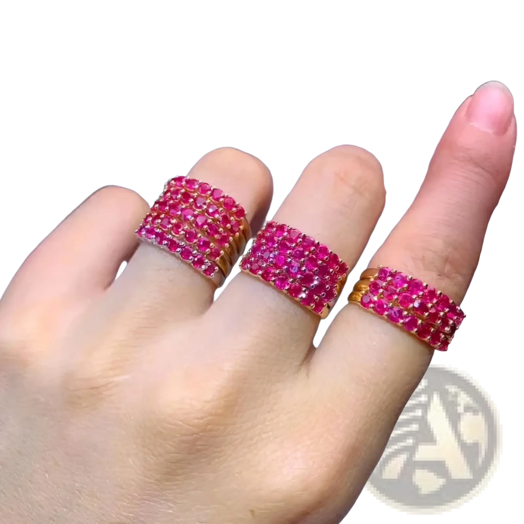 Three stacked natural ruby silver ring bands with gold settings displayed on a hand