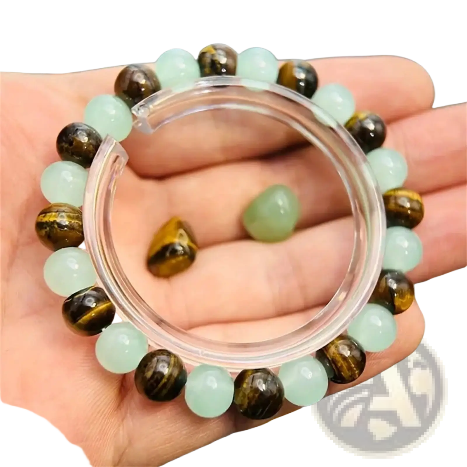 A hand holds a natural tiger eye and green aventurine beaded bracelet with translucent light green and golden brown stones