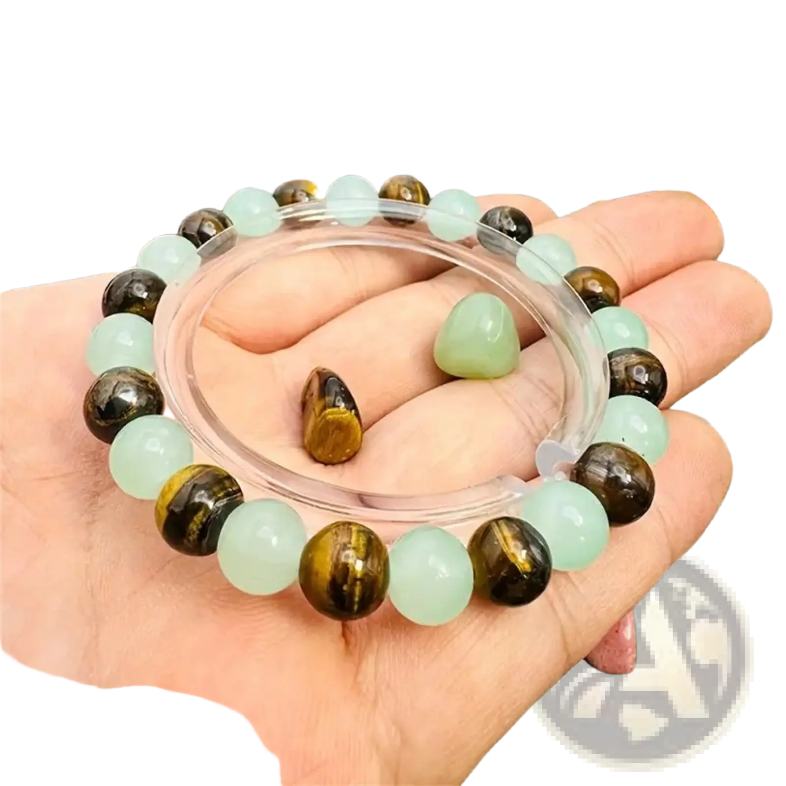 A hand holds a natural tiger eye and green aventurine beaded bracelet with alternating light green jade and tiger eye stones