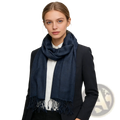 A navy jacquard herringbone scarf with textured fabric and fringed edges worn around the neck
