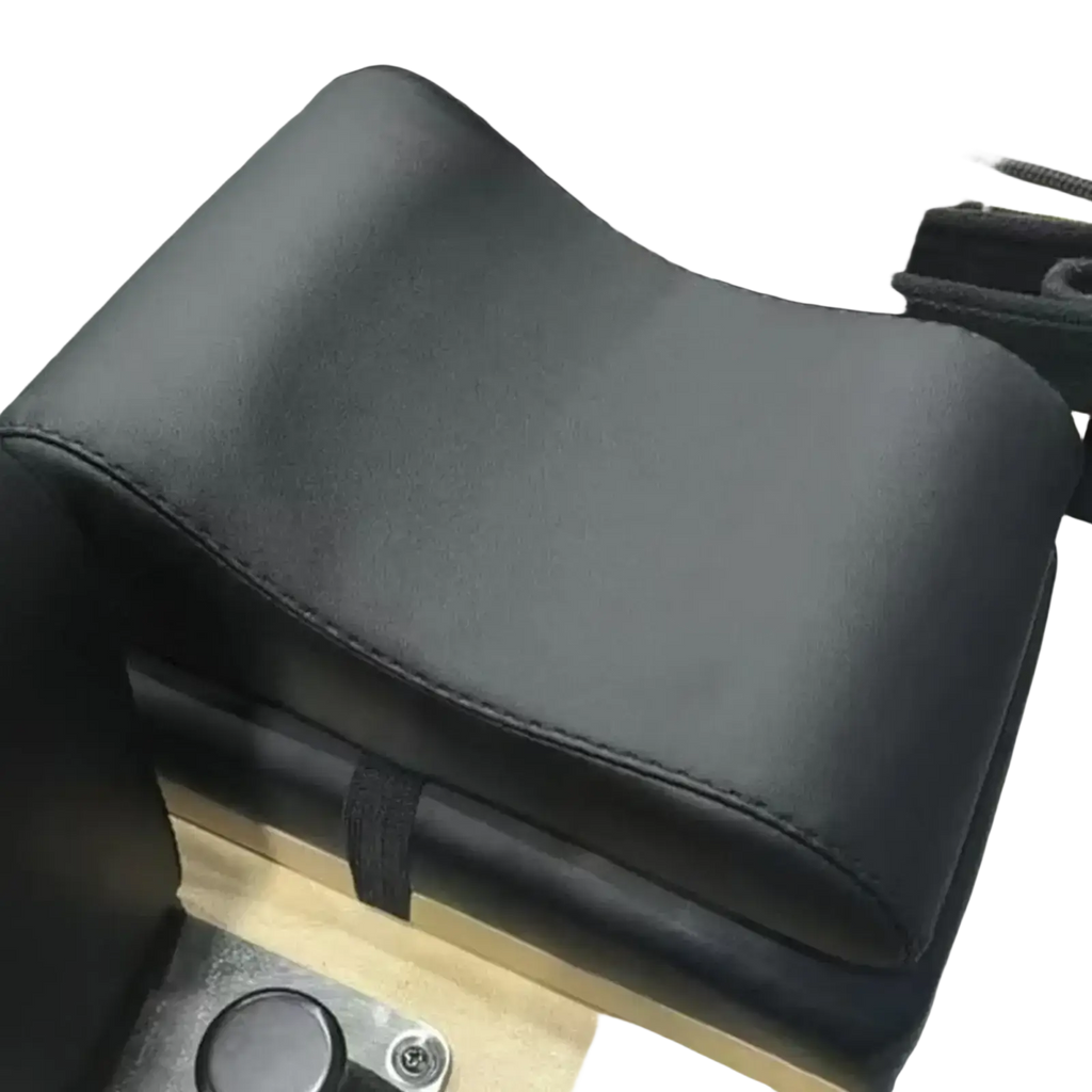 Black leather neck support pillow with stitched edges and contoured design for Pilates reformer use