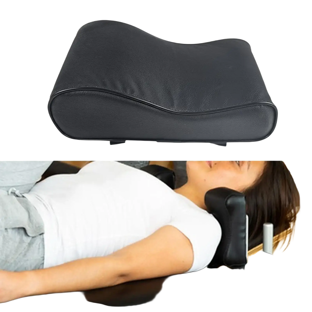 Black leather-like neck support pillow with contoured shape and adjustable straps for pilates reformer use