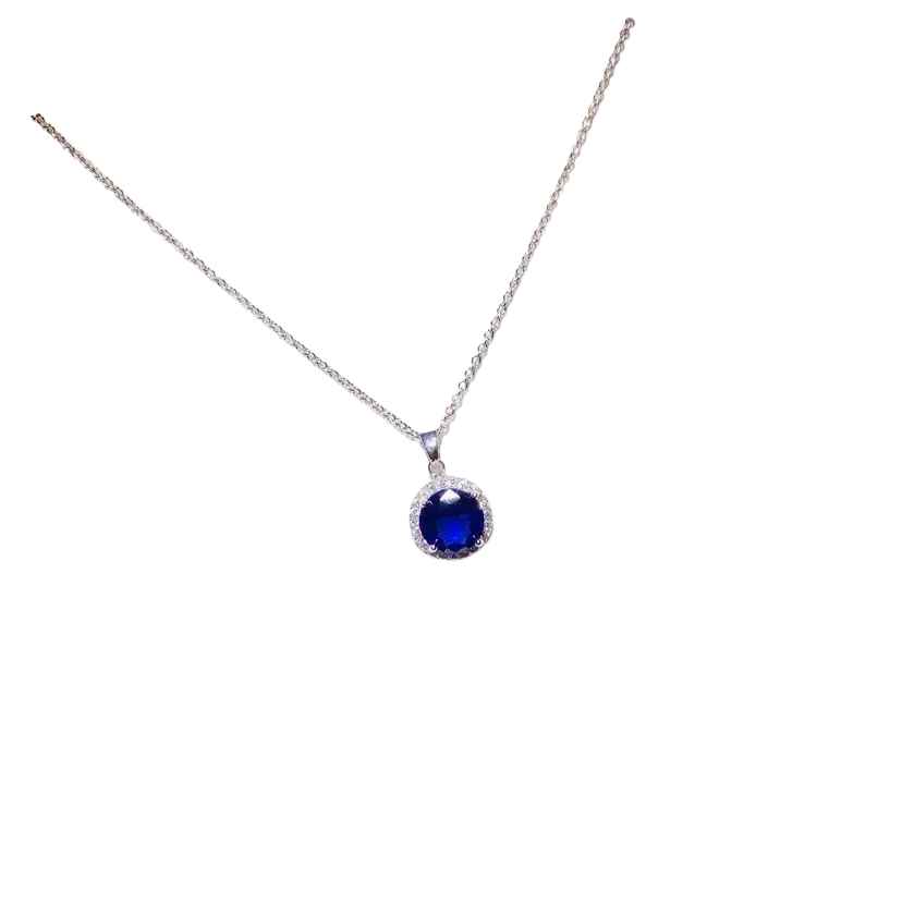 A delicate silver chain necklace pendant with a round created sapphire surrounded by clear stones fine jewelry