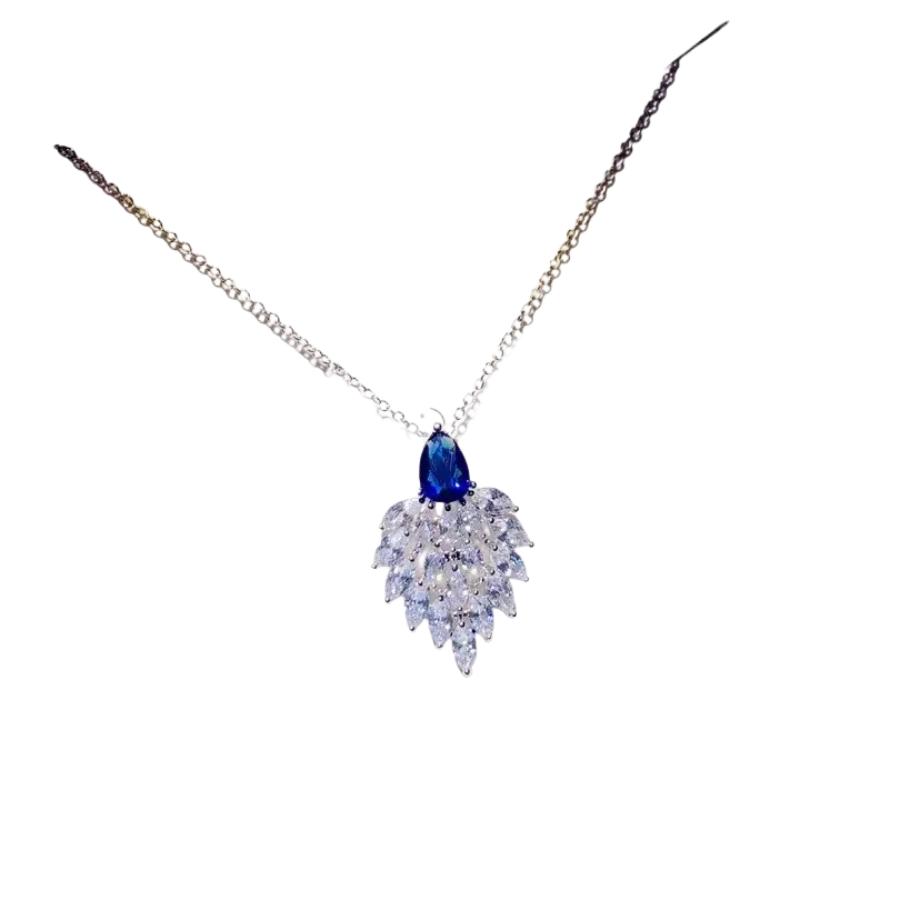 A delicate silver necklace pendant with a created sapphire teardrop and clear crystals in fine jewelry design