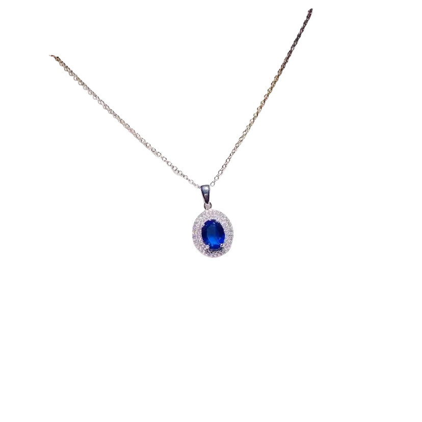 A delicate silver chain necklace pendant with an oval blue created sapphire surrounded by clear stones fine jewelry