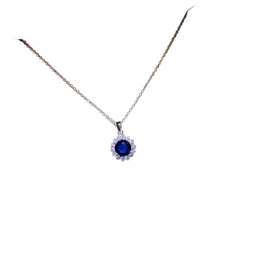 A delicate silver necklace pendant with a created sapphire and clear crystals in fine jewelry design on white card