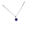 A delicate silver necklace pendant with a created sapphire and clear crystals in fine jewelry design on white card