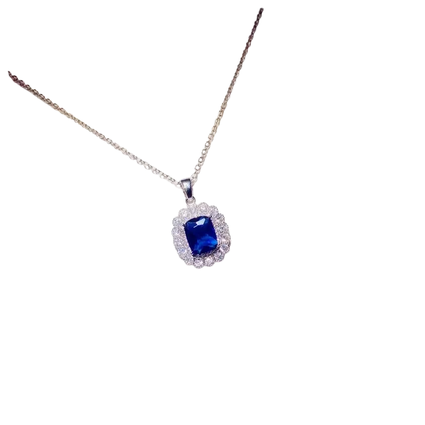 Delicate silver necklace pendant featuring a created sapphire blue gemstone surrounded by clear stones fine jewelry