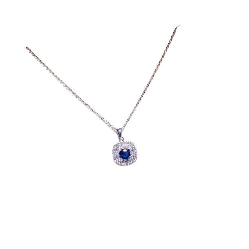 A delicate silver necklace pendant with a created sapphire blue gemstone surrounded by clear stones in fine jewelry