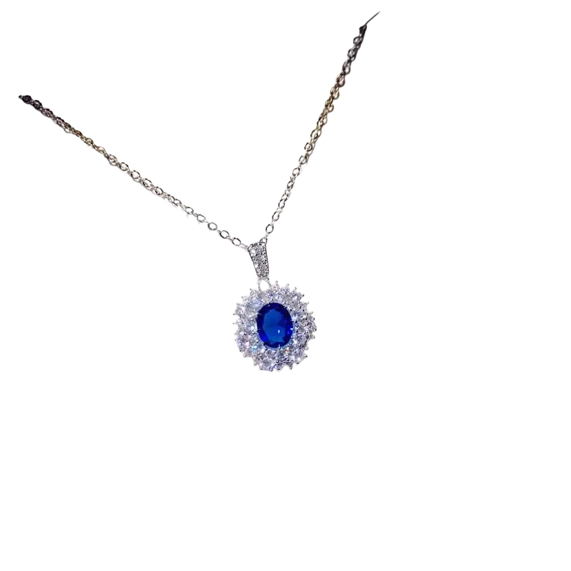 A delicate silver necklace pendant with a created sapphire blue gemstone surrounded by clear crystals fine jewelry