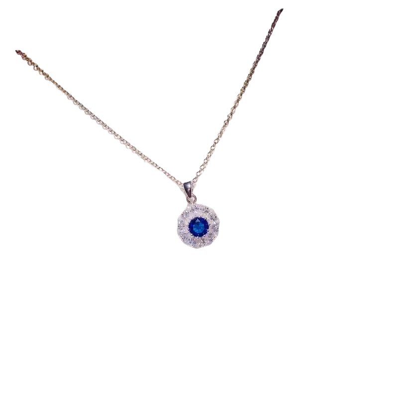 A delicate silver necklace pendant featuring a vibrant blue created sapphire surrounded by clear crystals fine jewelry