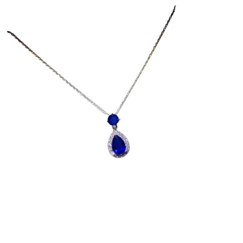 A delicate silver necklace pendant featuring a created sapphire teardrop surrounded by diamonds in fine jewelry design