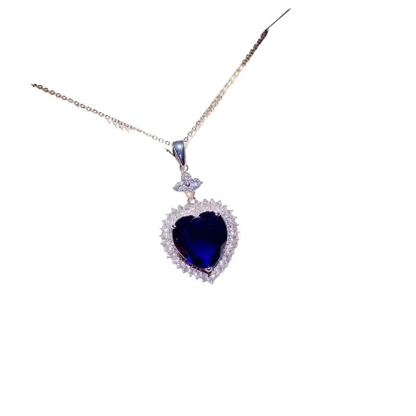 A sparkling heart-shaped necklace pendant with a created sapphire and clear crystals on a silver chain fine jewelry