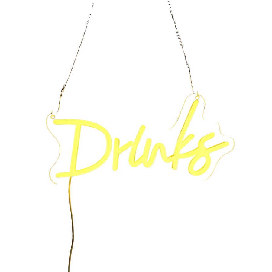 A glowing yellow neon sign with the word drinks in cursive script hanging by chains on a dark wall for wall decor