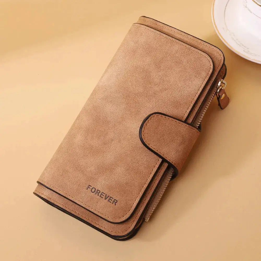 Tan suede women’s forever trifold buckle wallet with flap closure zipper detail and embossed forever on front