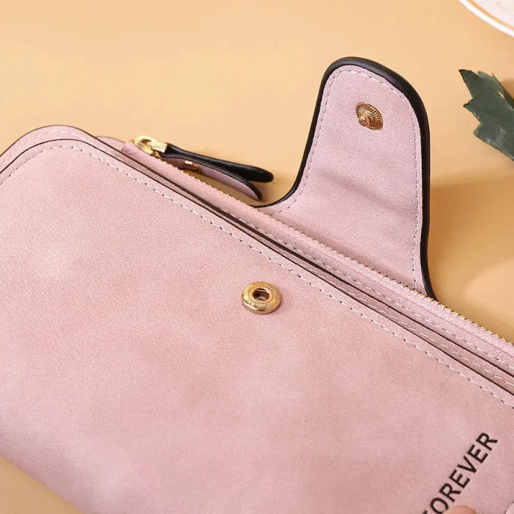 Women’s forever suede trifold buckle wallet in pink suede with gold-tone hardware and black trim