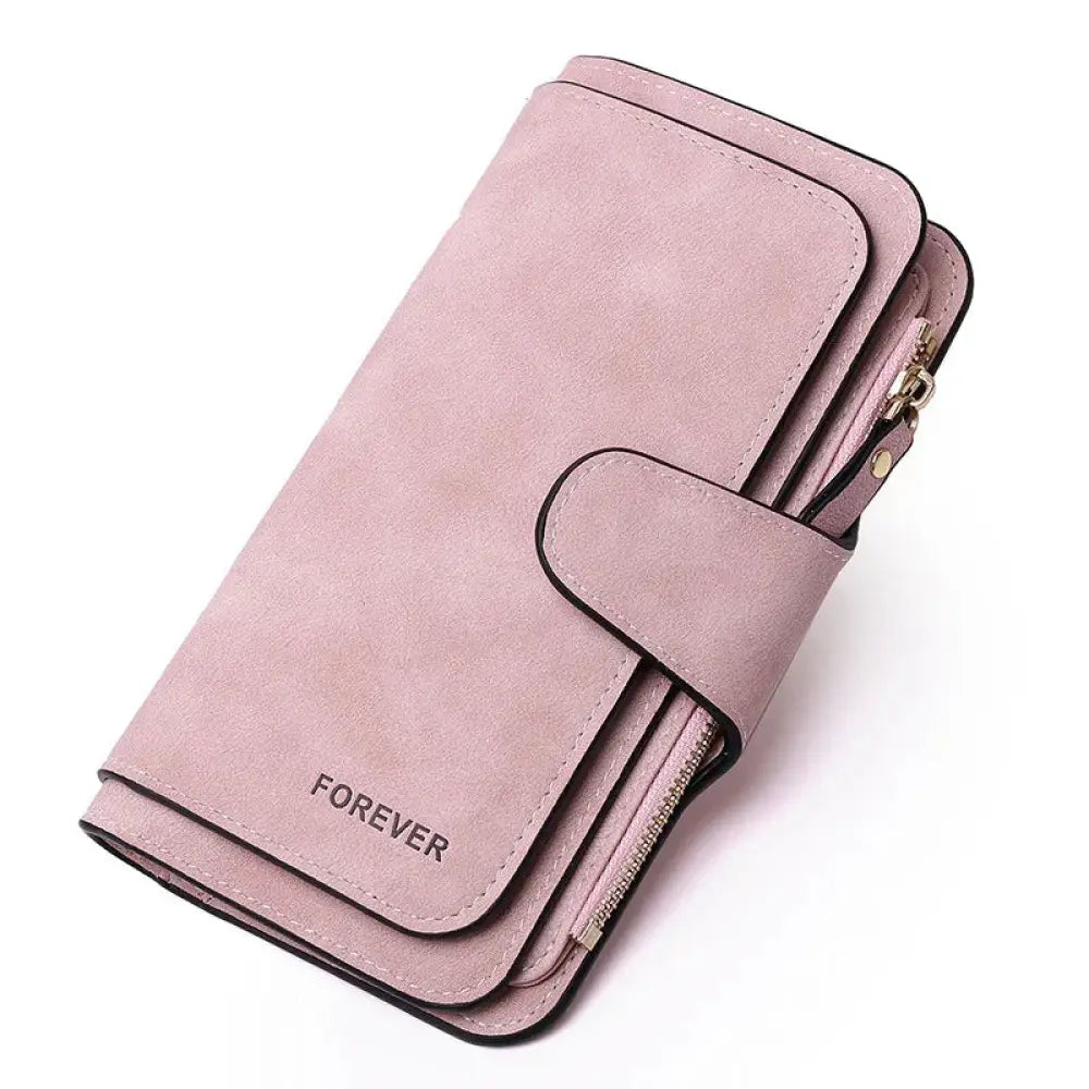 Women’s forever suede trifold buckle wallet in soft pink with black stitching and embossed logo on front flap