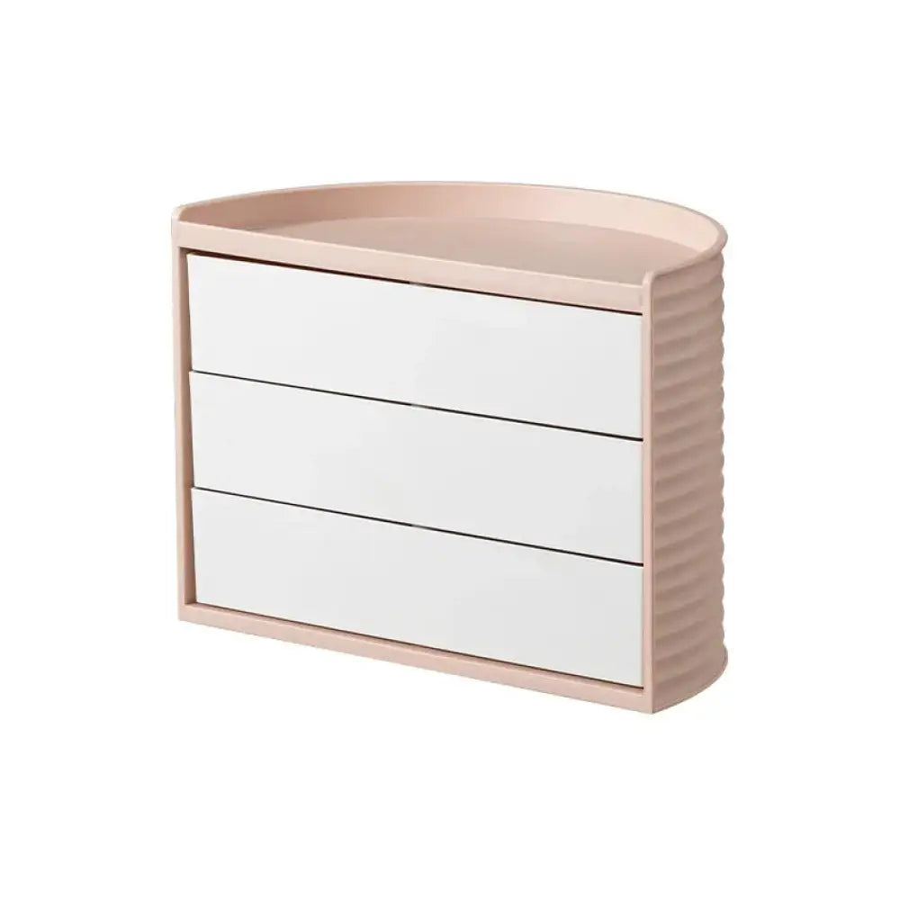 A sleek blush-pink three-drawer jewelry organizer with curved top and ribbed sides for 360 rotating makeup storage