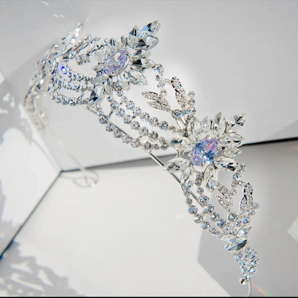 A sparkling silver bridal tiara with clear and lavender zirconia crystals in an intricate floral design