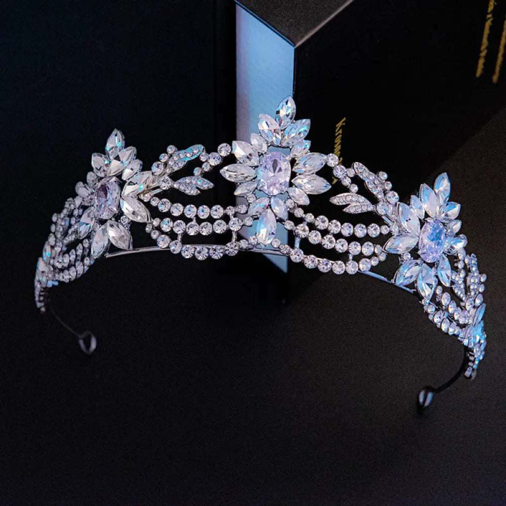 A sparkling silver bridal tiara with intricate floral designs and cascading pastel zirconia crystals