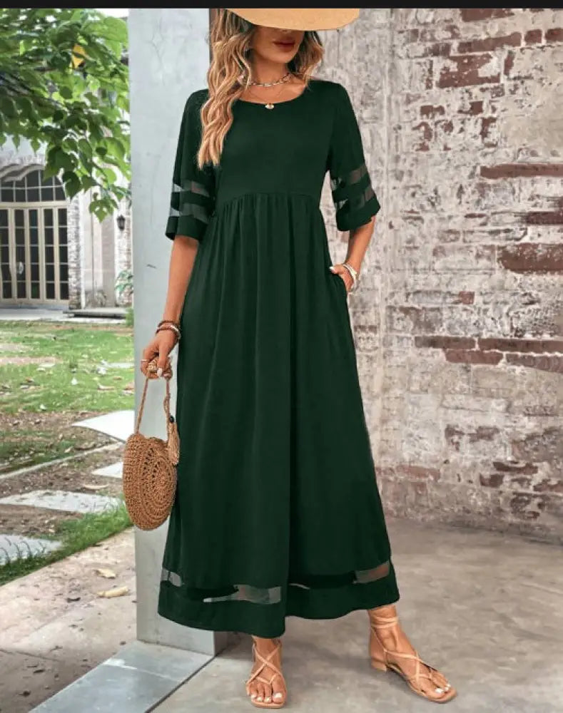 A flowing dark green mesh patchwork maxi dress with sheer accents and side pockets in a relaxed fit